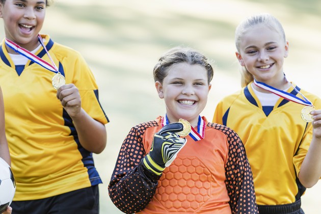 Soccer players smiling with their medals.