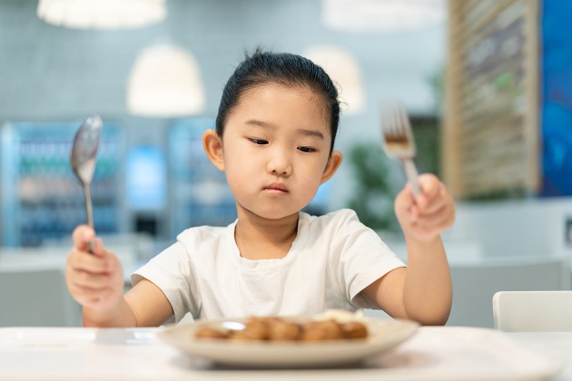 A picky child looking at their food.