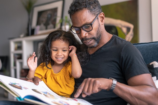 A parent reading a picture book to a young child.