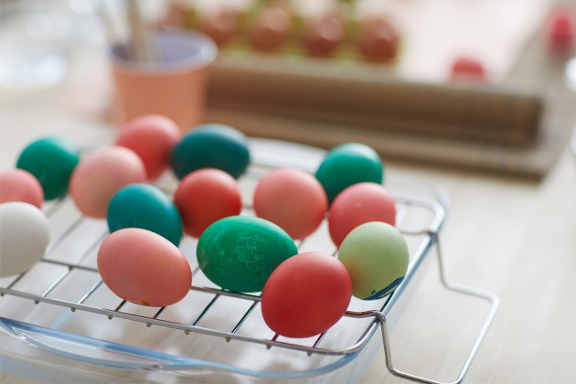 Colored Easter eggs on a wire rack.
