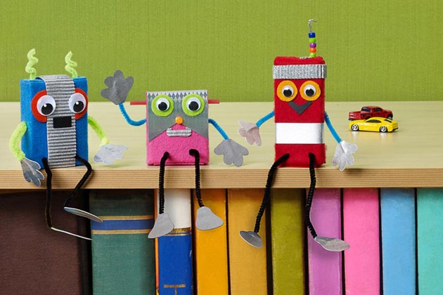 Craft robot toys made from small cardboard boxes decorated with felt, googly eyes and chenille stems.