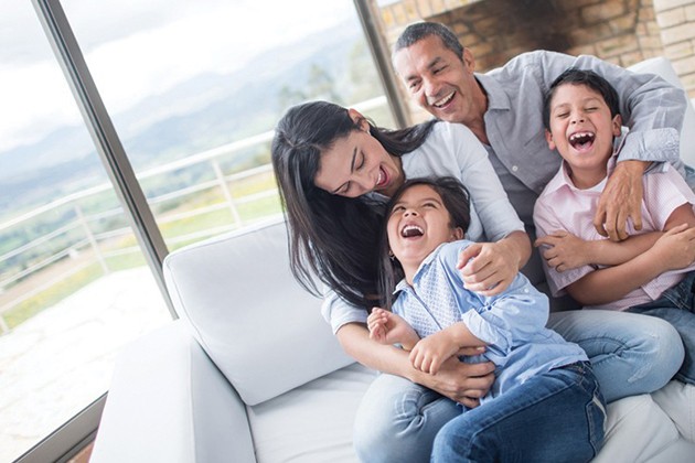 Happy family sitting on couch near window