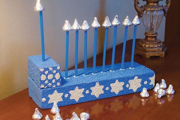 A play menorah made of painted foam and candy kisses.