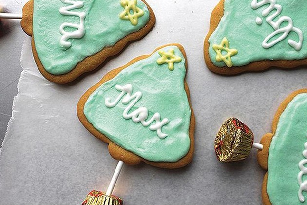 Cookies shaped like Christmas trees with peanut butter cup bases.