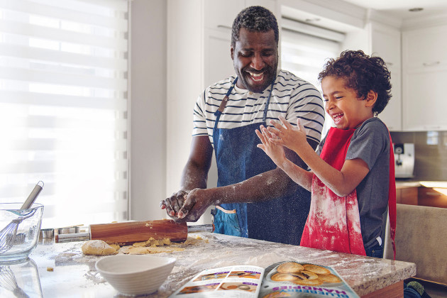 Parent and child baking together in kitchen