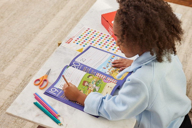young child practicing learning with workbook