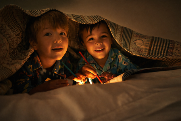 kids under blanket with flashlight