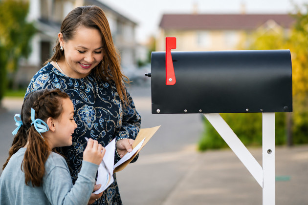 parent and child opening a mailbox 