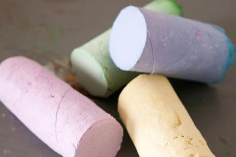4 sticks of homemade sidewalk chalk on the pavement.