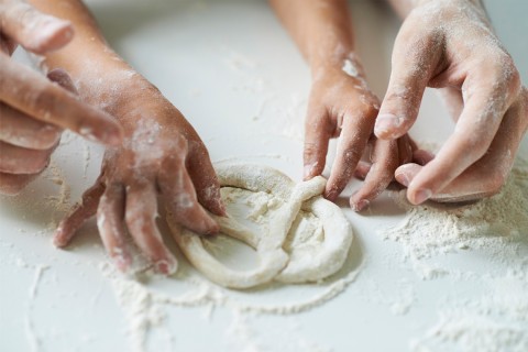 Parent and child making pretzels.