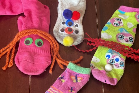 Sock puppets decorated with googly eyes and yarn hair.