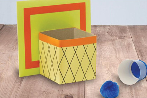 Homemade tabletop basketball hoop made from cardboard.