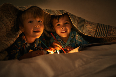 kids under blanket with flashlight